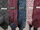 several different colored ties hanging on a rack in a room