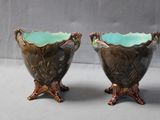 two brown and green vases sitting next to each other on a table