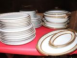 many plates and bowls sitting on a red table