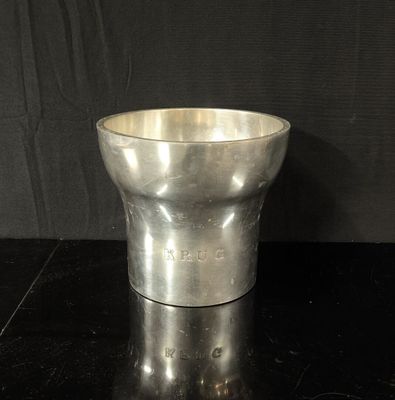 une tasse en métal posée sur une table noire
