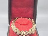 une couronne en or dans un coffret rouge sur fond blanc