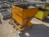 une benne jaune posée sur une palette, dans la terre