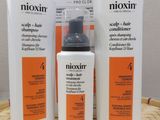 three bottles of nioxin hair care sitting on a table