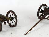 pair of antique cast iron cannon wheels with wooden spokes
