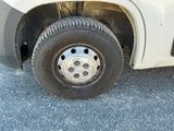a white truck with a flat tire parked in a parking lot