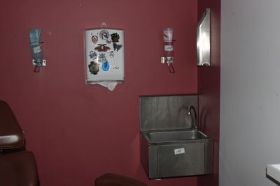 une photo d'une salle de bains avec un lavabo et des murs rouges