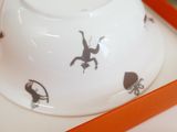 a white bowl with black drawings on it in a box