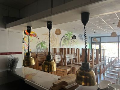 des tables et des chaises dans un restaurant orné d'une fresque murale
