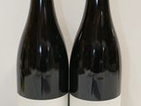 deux bouteilles de vin posées l'une à côté de l'autre sur une table