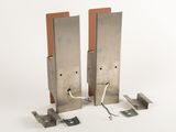 two pieces of metal with wires attached to them on a white surface
