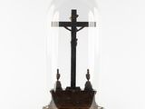 an image of a cross under a glass dome on a stand
