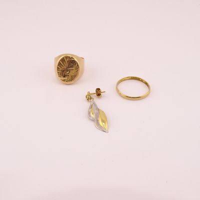 deux bagues en or et une bague en forme de plume sur un fond blanc