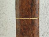 a close up of a brown book with a red stripe on it