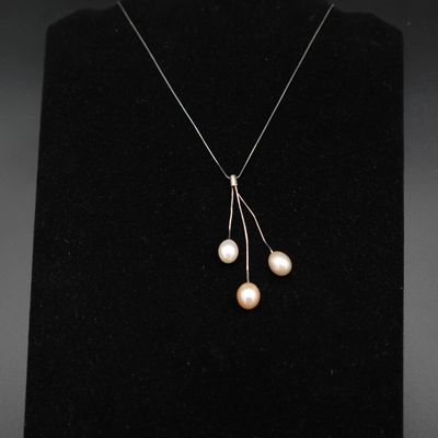 un collier de perles blanches et d'argent sur un mannequin noir