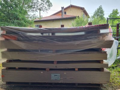 un tas de bois posé par terre devant une maison