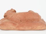 figurine of a dog laying on a pillow on a white surface