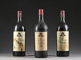 three bottles of wine are lined up on a table