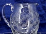 a glass pitcher sitting on top of a glass plate