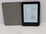 a kindle that is sitting on a table next to a book