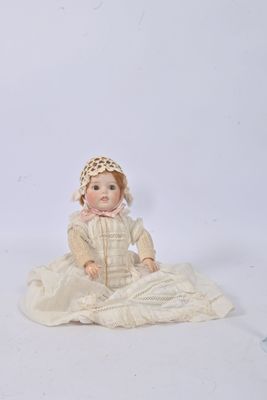 a doll that is sitting on the ground with a hat on