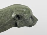 a green statue of a dog with a black nose