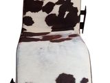 brown and white cow print chair with black leather seat