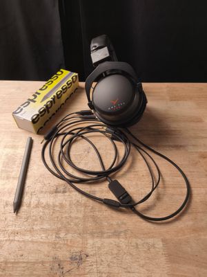 un casque posé sur une table à côté d'un stylo