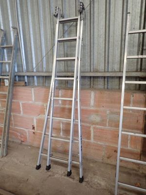three ladders leaning against a wall in a building