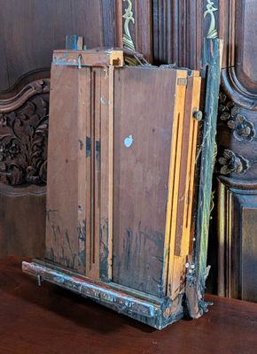 a wooden easel with a painting on it on a table