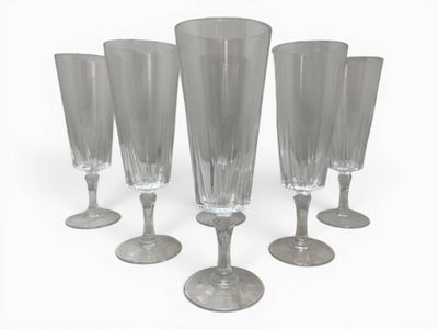 four clear wine glasses sitting on top of each other on a white surface
