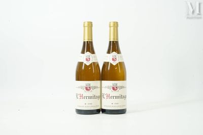 two bottles of white wine sitting next to each other on a white surface