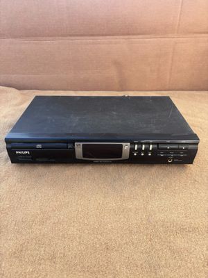 un lecteur DVD noir posé sur un canapé marron