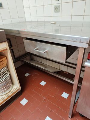 une cuisine équipée d'un plan de travail en inox et d'un lave-vaisselle