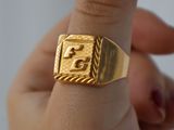 une personne tenant une bague en or sur laquelle est gravé un numéro