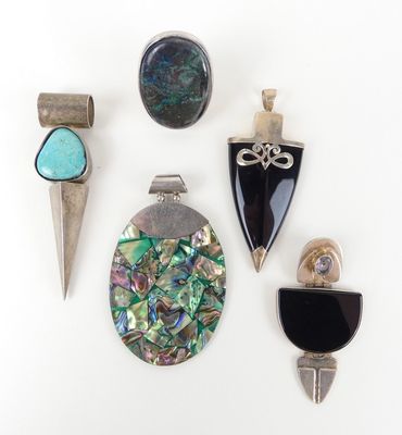 Plusieurs bijoux différents sont exposés sur une surface blanche