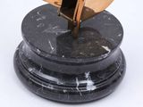 a sculpture of a plane on a black marble base