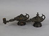 pair of antique brass oil lamps on pedestals on a white background