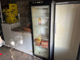 two refrigerators that are open in a garage