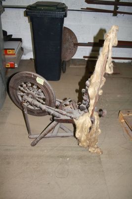 an old spinning machine in a garage with a trash can in the background
