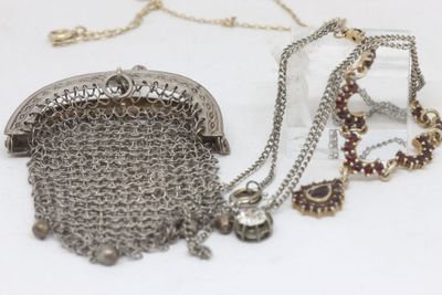 a silver purse with a chain around it on a table