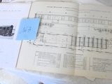 un livre ouvert posé sur une table, sur lequel est collé un autocollant bleu