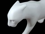 a white cat figurine on a black background