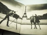 an open book with a black and white photo of two people in front of the eiffel tower