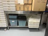 de nombreux bacs et cartons posés sur une étagère métallique dans une pièce