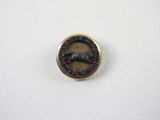 un petit bouton en bronze sur lequel est représenté un cheval