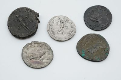 quatre pièces de monnaie romaines anciennes, dont l'une a été nettoyée et l'autre a été nettoyée