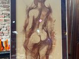 a picture of a drawing of a nude woman on a easel