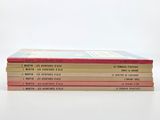 four books stacked on top of each other on a white surface