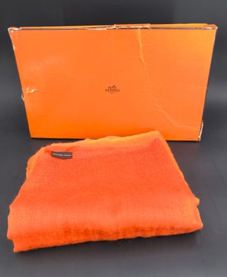 une écharpe orange et une boîte sur fond noir