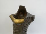 une sculpture en bronze représentant un vase orné d'un coquillage